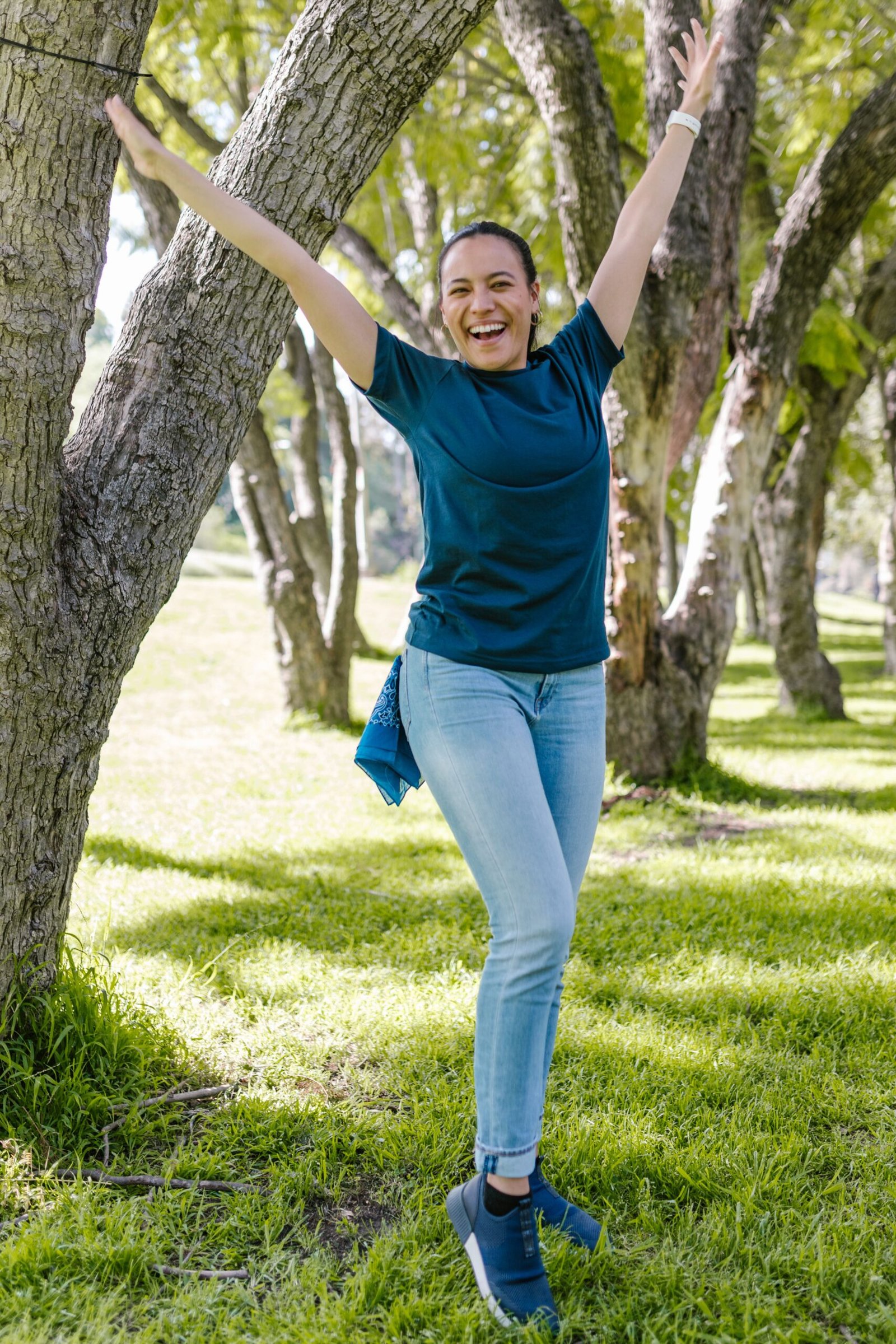 Smiling woman facing the camera with arms raised, representing positive energy and mitochondrial vitality